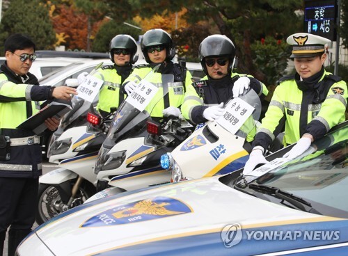 대학수학능력시험을 이틀 앞둔 12일 오후 경기도 수원남부경찰서에서 경찰이 수험생 지원 활동에 사용될 순찰차와 경찰 오토바이에 안내문을 부착하고 있다. [사진= 연합뉴스]