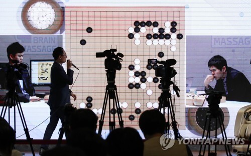 이세돌 9단이 18일 서울 강남구 바디프랜드 도곡타워에서 열린 '바디프랜드 브레인마사지배 이세돌 vs 한돌' 은퇴 대국 제1국 모습을 기자회견장에서 화면으로 중계해 주고 있다. [사진= 연합뉴스]
