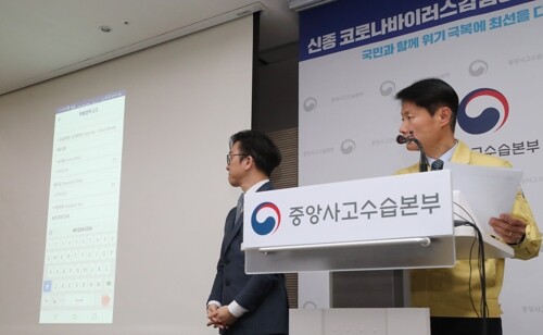 김강립 중앙사고수습본부 부본부장(보건복지부 차관, 오른쪽)이 10일 오전 세종시 정부세종청사에서 신종 코로나바이러스 감염증 대응 정례브리핑을 마친 뒤 '자가진단 앱' 시연을 하고 있다.  [사진= 연합뉴스]