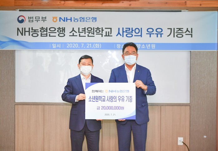 21일 경기도 안양시 만안구에 위치한 안양소년원에서 농협은행 농업·공공금융부문 지준섭 부행장(사진 오른쪽)과 법무부 범죄예방정책국 강호성 국장(사진 왼쪽)이 사랑의 우유 기증식을 갖고 기념촬영을 하고 있다.(사진=NH농협은행)